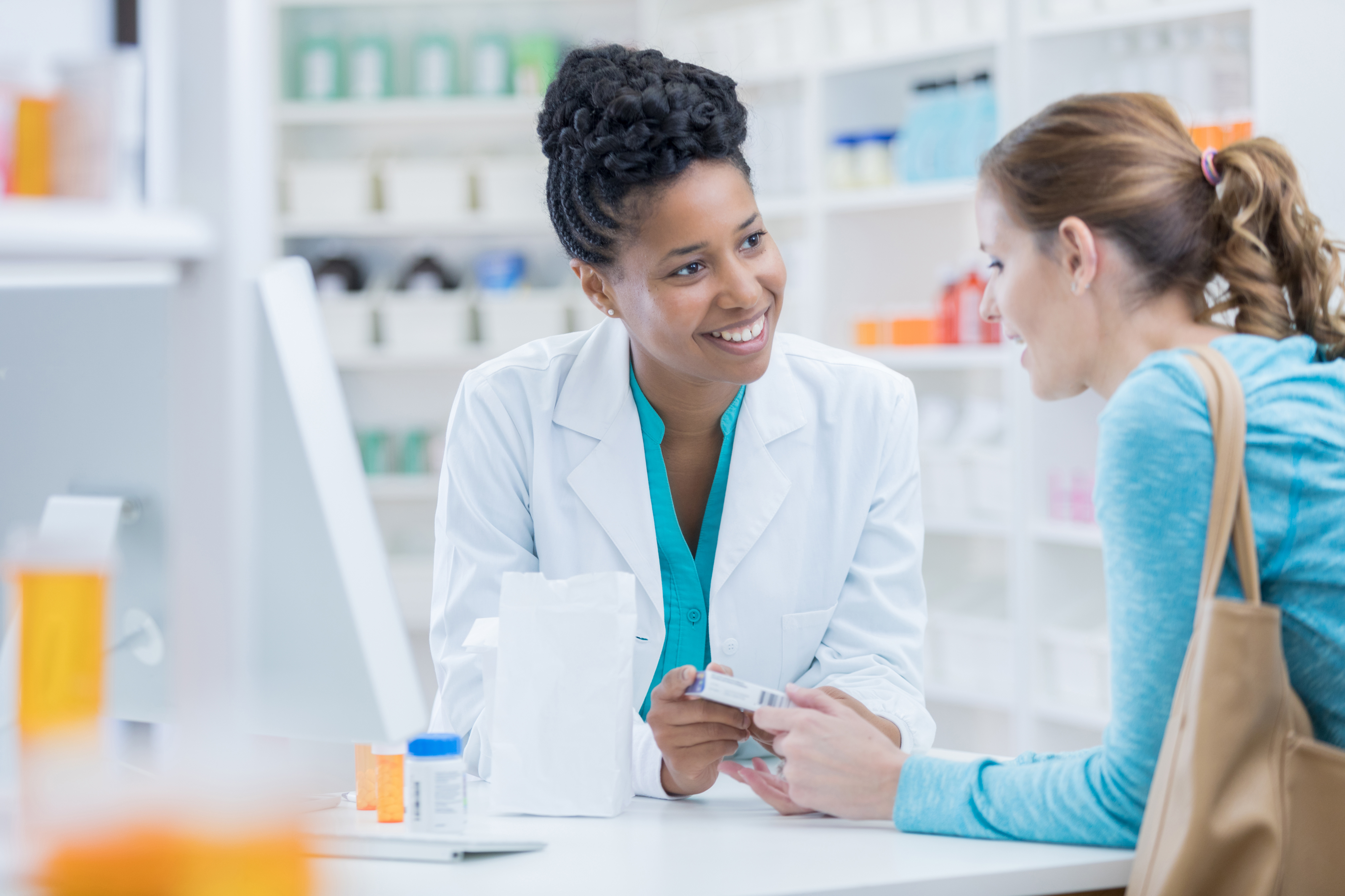 Woman pharmacist talking to female customer