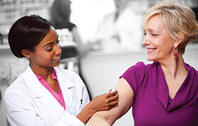 Medical worker applying adhesive bandage to woman's arm