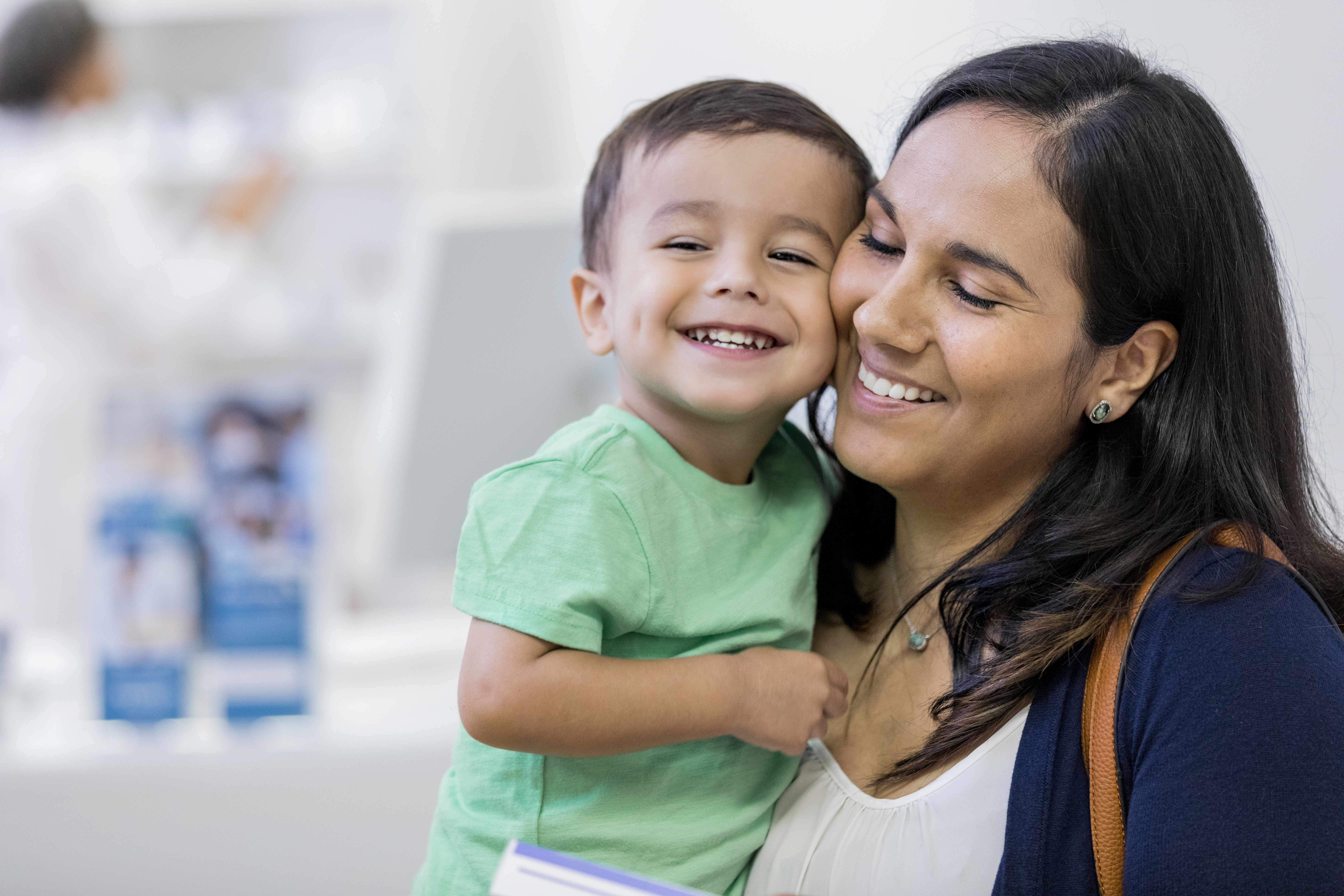 Smiling woman holding a toddler boy