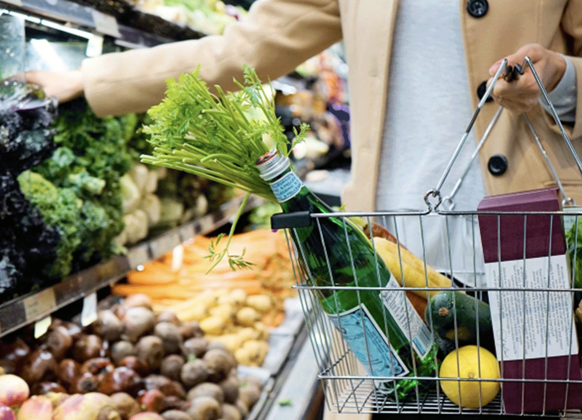 Man holding grocery basket near fresh vegetable section