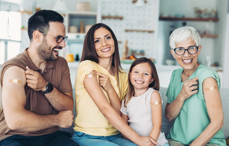 family-smiling-together-showing-their-vaccinated-spot-on-right-arm