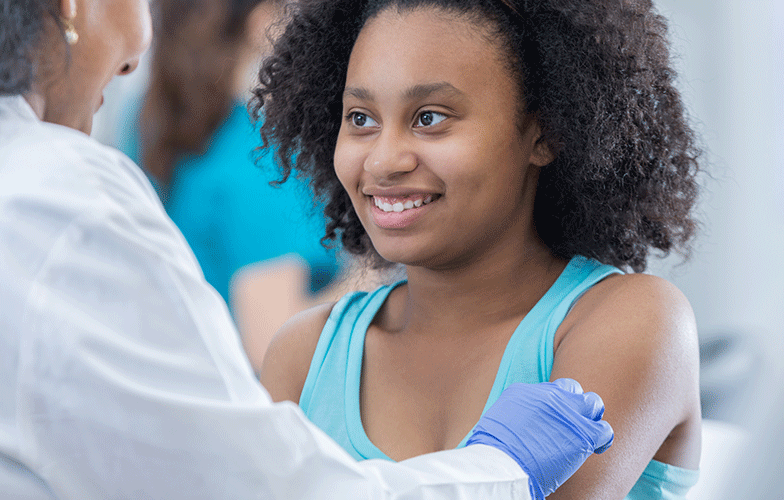 Young girl smiling while getting vaccinated